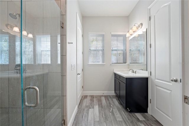 bathroom with walk in shower, hardwood / wood-style flooring, and vanity