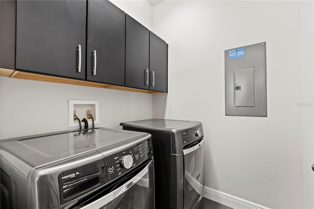 laundry area featuring cabinets, independent washer and dryer, and electric panel