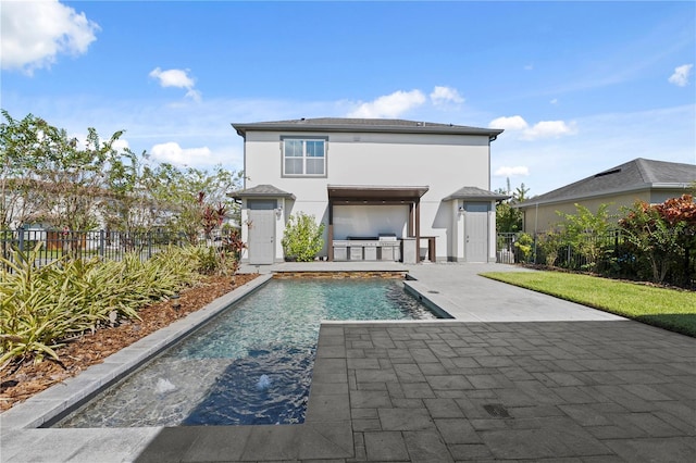 back of property with a patio and a fenced in pool