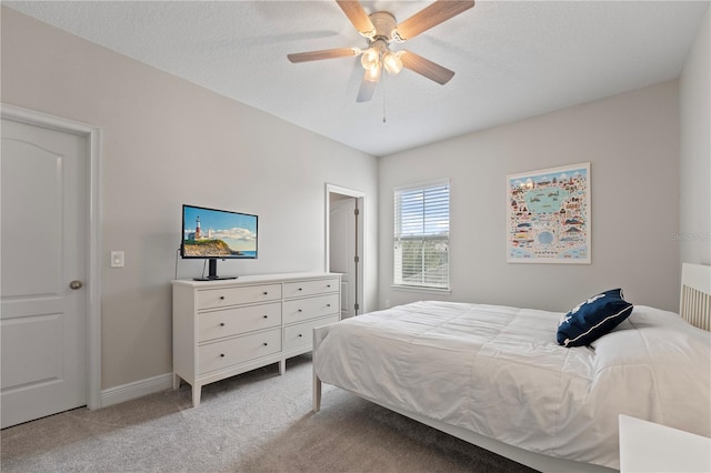 bedroom featuring a textured ceiling, light carpet, and ceiling fan