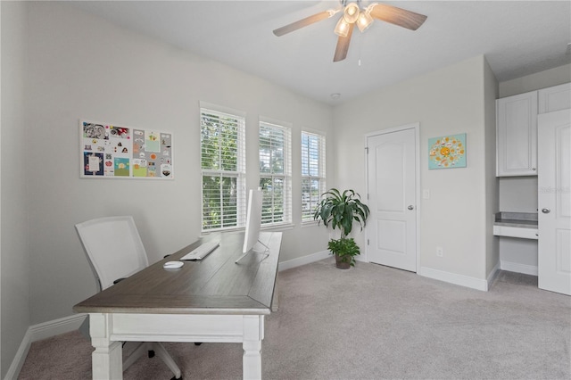 carpeted office space with ceiling fan