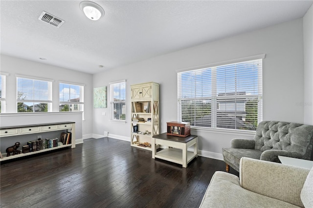 living area featuring a textured ceiling and dark hardwood / wood-style flooring