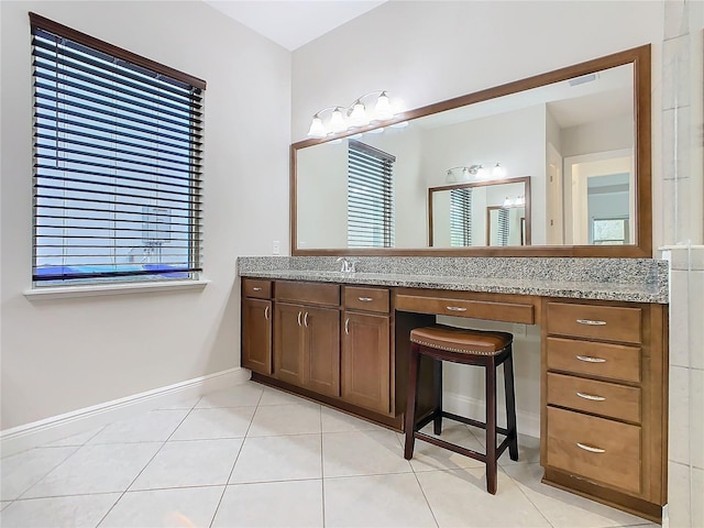 bathroom with visible vents, baseboards, tile patterned flooring, vanity, and a wealth of natural light