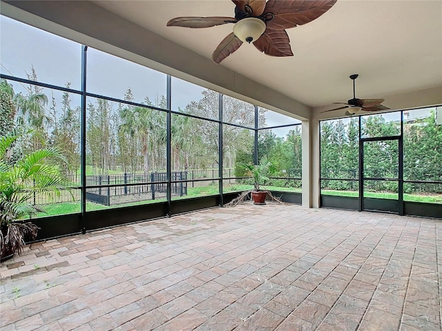 unfurnished sunroom with a ceiling fan