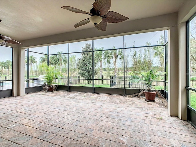 unfurnished sunroom with ceiling fan