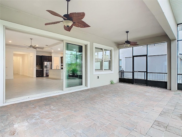 unfurnished sunroom featuring a ceiling fan