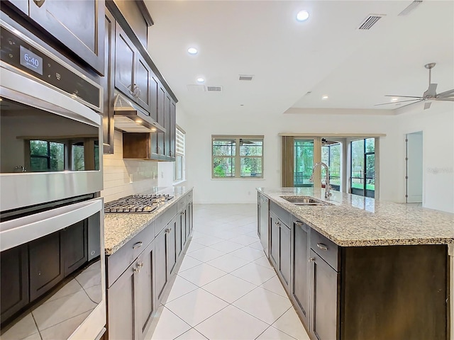 kitchen with light tile patterned floors, tasteful backsplash, stainless steel appliances, a sink, and recessed lighting