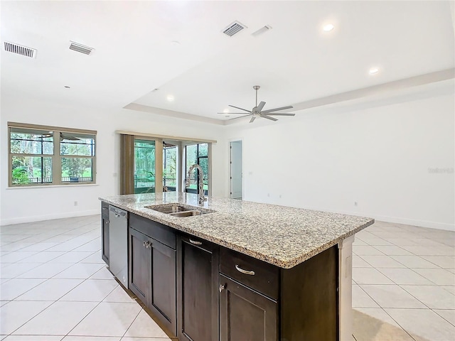 kitchen with a raised ceiling, stainless steel dishwasher, a sink, and visible vents