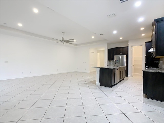 kitchen with light tile patterned floors, stainless steel fridge, and open floor plan