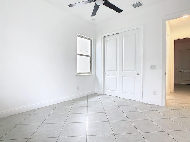 unfurnished bedroom with light tile patterned floors, baseboards, visible vents, and a closet