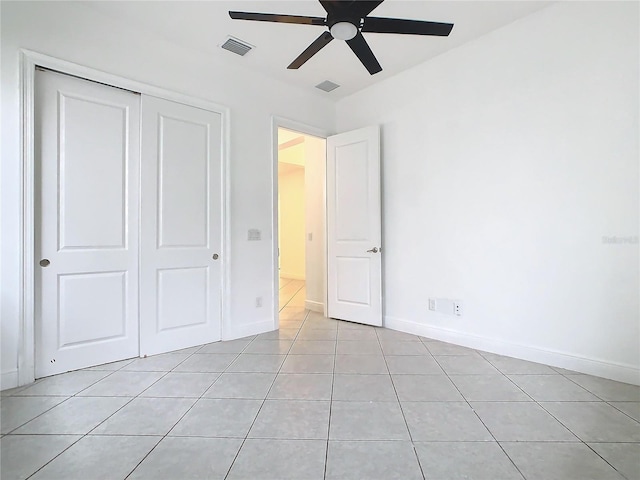 unfurnished bedroom with a closet, visible vents, baseboards, and light tile patterned flooring