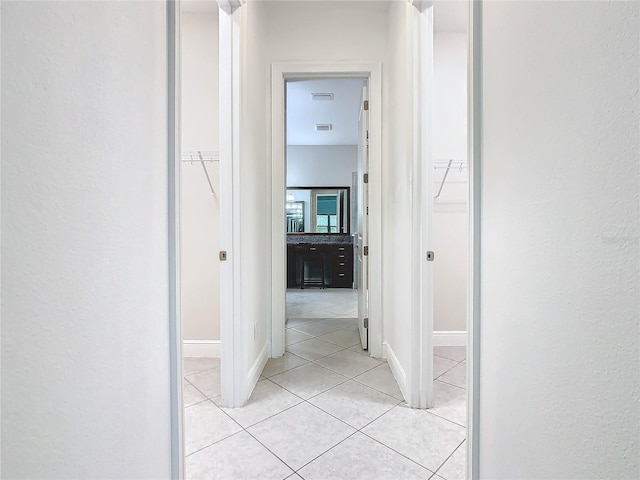 hall with light tile patterned floors and baseboards