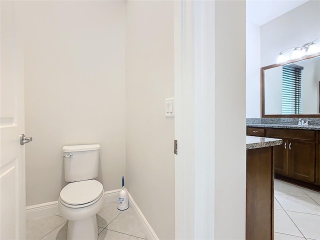 bathroom with vanity, tile patterned flooring, toilet, and baseboards