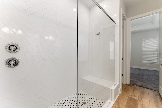 bathroom featuring hardwood / wood-style floors and a tile shower