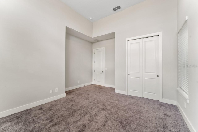 unfurnished bedroom featuring carpet and a closet