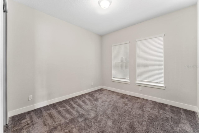 empty room featuring dark colored carpet