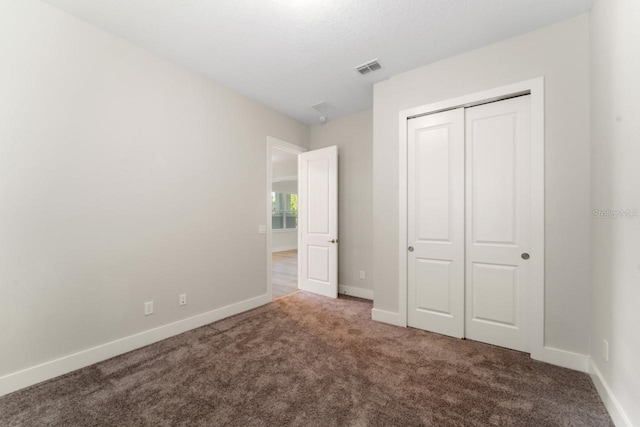 unfurnished bedroom with a closet and carpet flooring