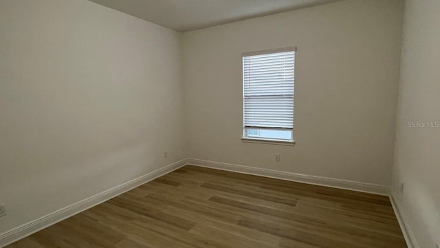 unfurnished room with dark hardwood / wood-style flooring