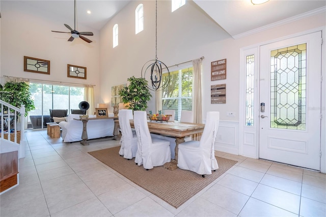 dining space featuring ceiling fan, light tile patterned floors, plenty of natural light, and a high ceiling