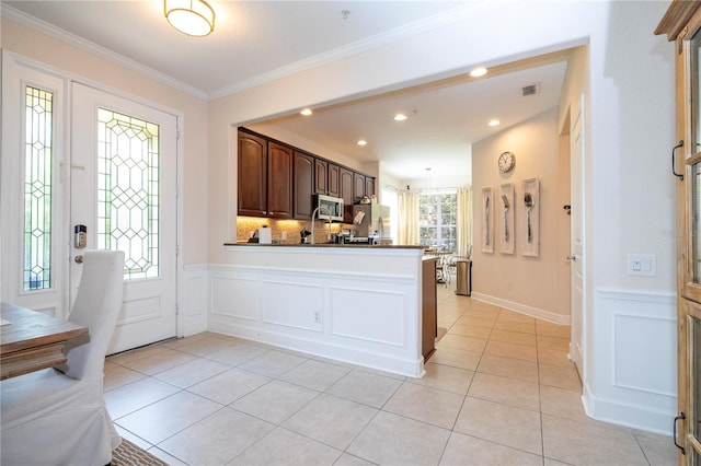 kitchen featuring kitchen peninsula, dark brown cabinets, stainless steel appliances, and a wealth of natural light