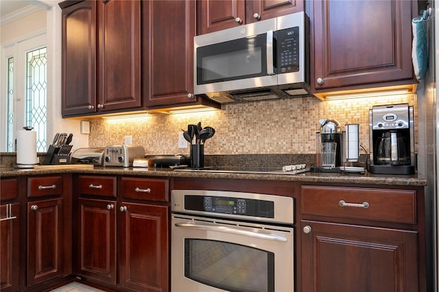 kitchen with backsplash, appliances with stainless steel finishes, and ornamental molding