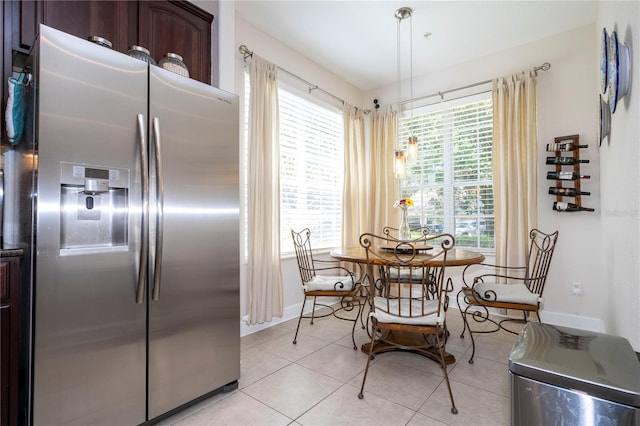 kitchen featuring dark brown cabinetry, light tile patterned floors, and stainless steel fridge with ice dispenser