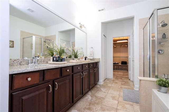 bathroom featuring vanity and a shower with shower door