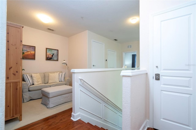 corridor featuring a textured ceiling and hardwood / wood-style floors