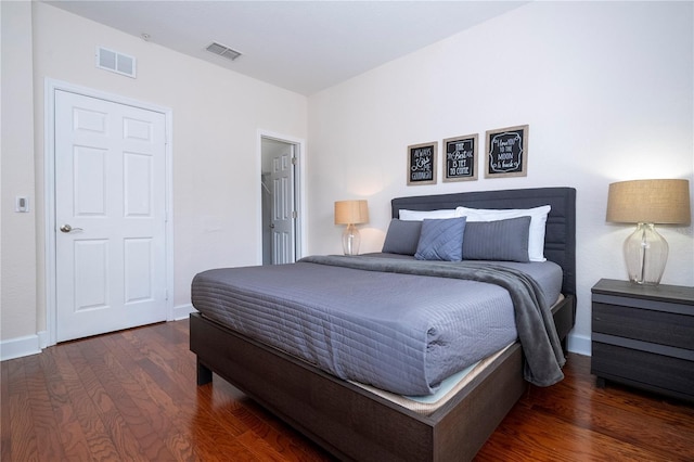 bedroom with baseboards, wood finished floors, and visible vents