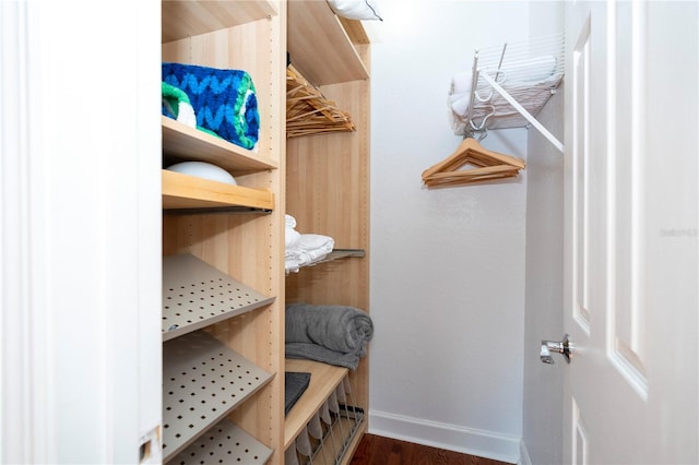 spacious closet with dark hardwood / wood-style floors