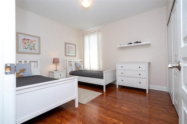 bedroom featuring baseboards and wood finished floors