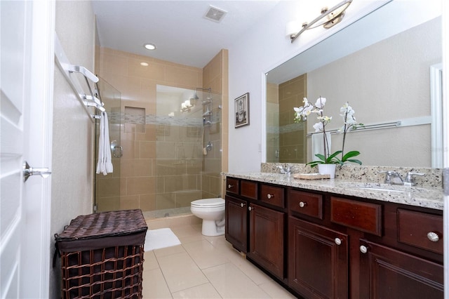 bathroom with a sink, toilet, double vanity, tile patterned floors, and a stall shower
