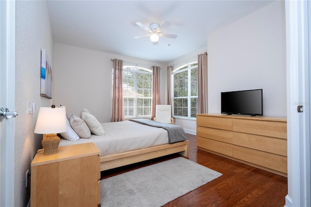 bedroom with baseboards, ceiling fan, and wood finished floors