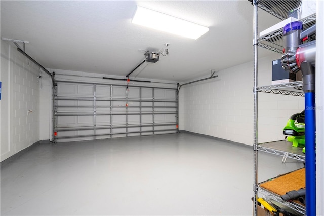 garage with concrete block wall and a garage door opener