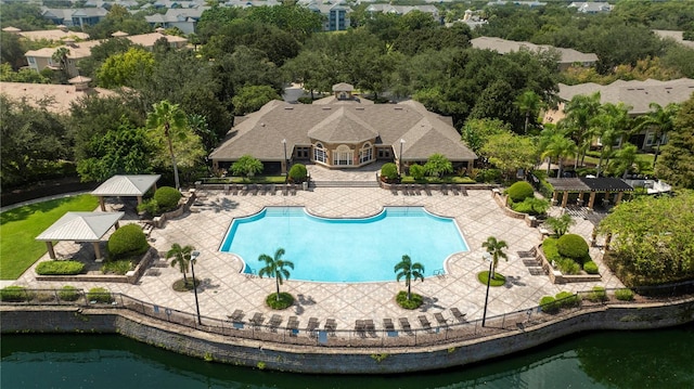 community pool featuring a water view, a gazebo, fence, and a patio area