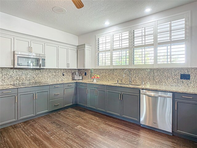 kitchen featuring sink, stainless steel appliances, dark wood-type flooring, plenty of natural light, and gray cabinets