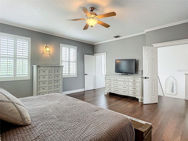 bedroom with a textured ceiling, dark wood-type flooring, ceiling fan, and ornamental molding