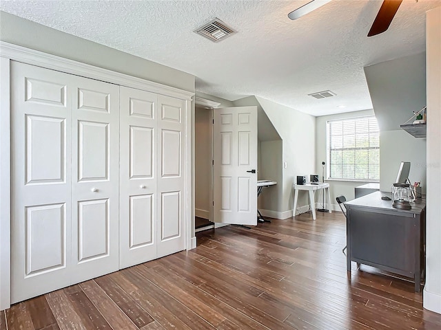 bonus room featuring ceiling fan, dark hardwood / wood-style flooring, and a textured ceiling