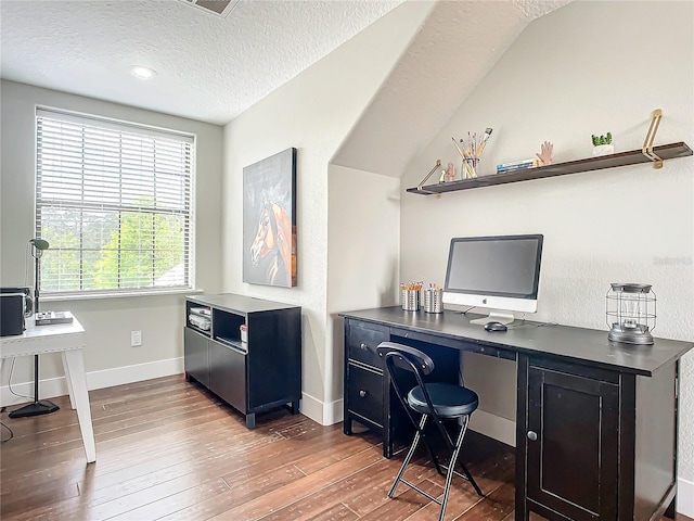 home office featuring dark hardwood / wood-style flooring, a textured ceiling, and lofted ceiling