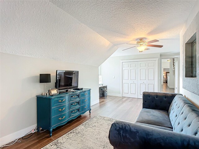 sitting room featuring a textured ceiling, dark hardwood / wood-style floors, ceiling fan, and lofted ceiling