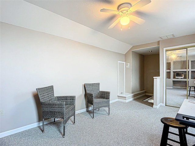 sitting room featuring ceiling fan, light colored carpet, and vaulted ceiling