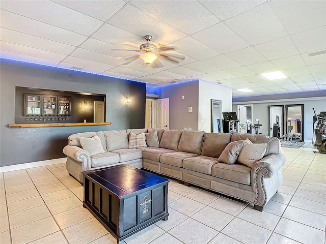 tiled living room with a paneled ceiling and ceiling fan