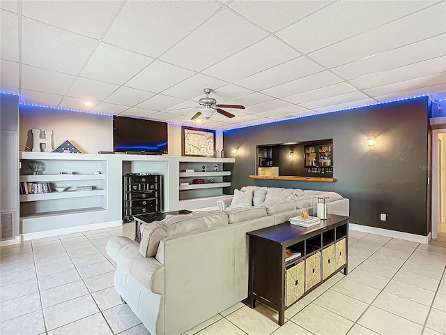 tiled living room featuring a paneled ceiling, built in features, and ceiling fan