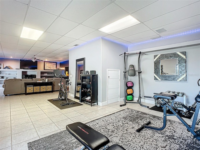 exercise area featuring light tile patterned floors and a paneled ceiling