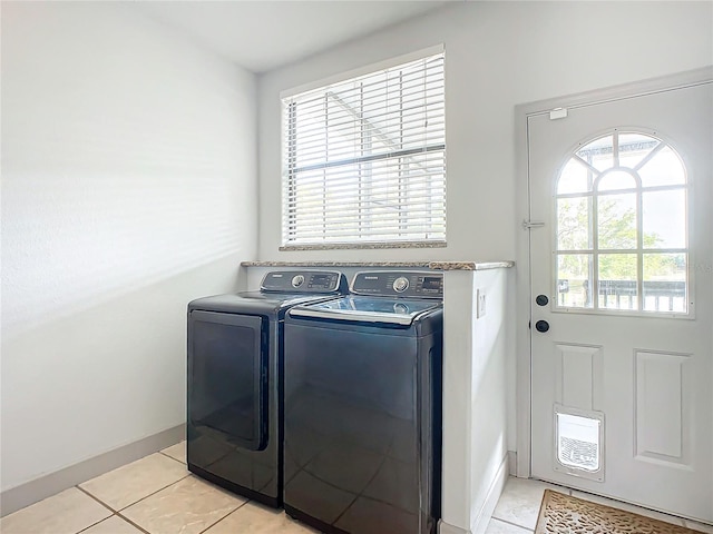 laundry area featuring a wealth of natural light, light tile patterned floors, and washer and dryer