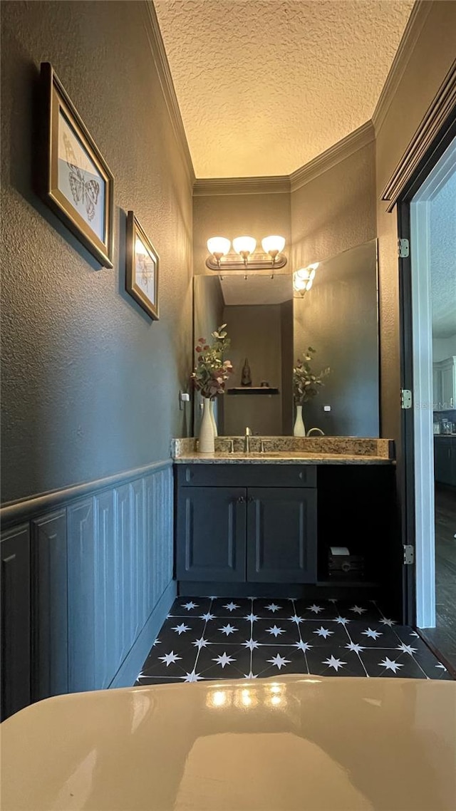 bathroom with crown molding, vanity, and a textured ceiling