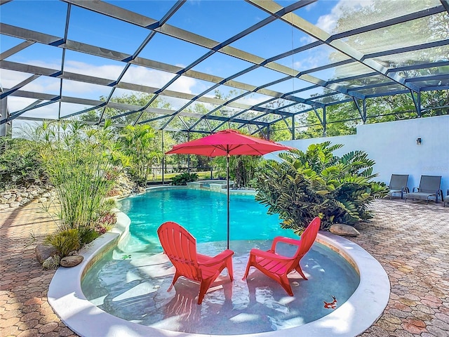 view of pool featuring glass enclosure and a patio area