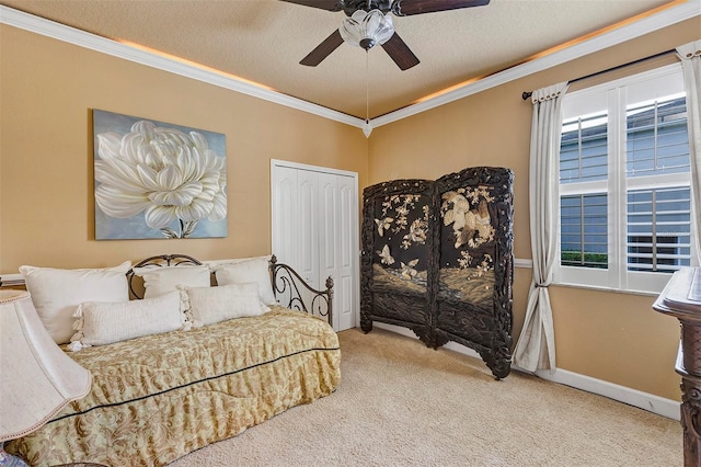 carpeted bedroom with ceiling fan, ornamental molding, a textured ceiling, and a closet