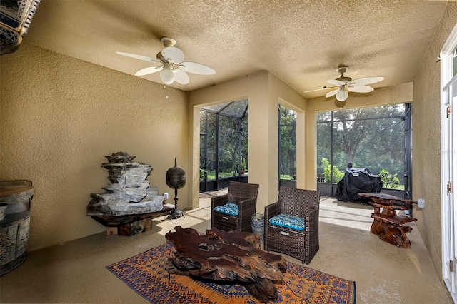 living area with ceiling fan and a textured ceiling