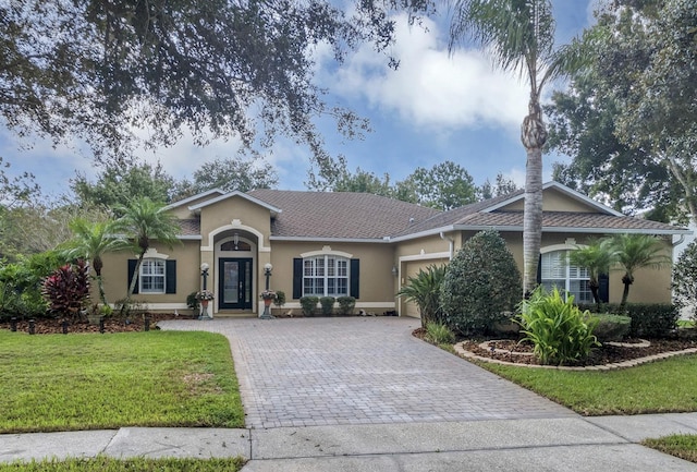 single story home featuring a garage and a front lawn